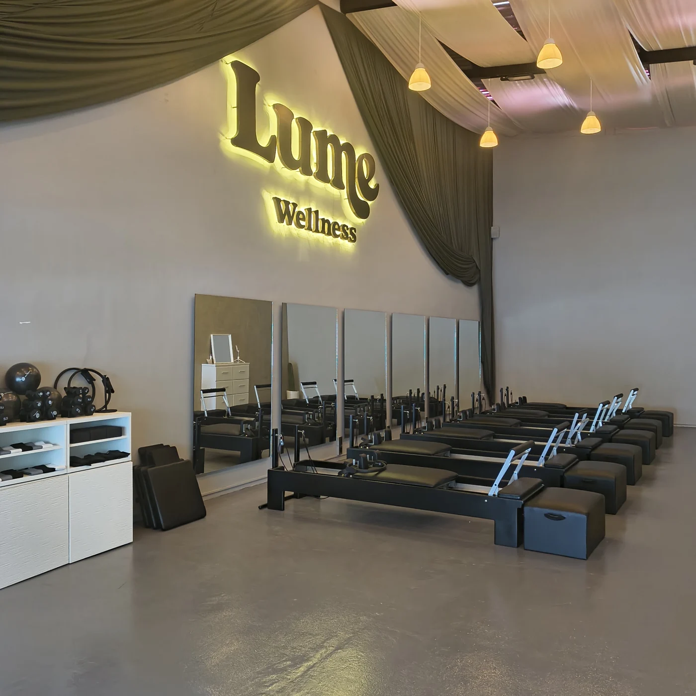 Estudio Pilates Reformer con letrero LUME Wellness